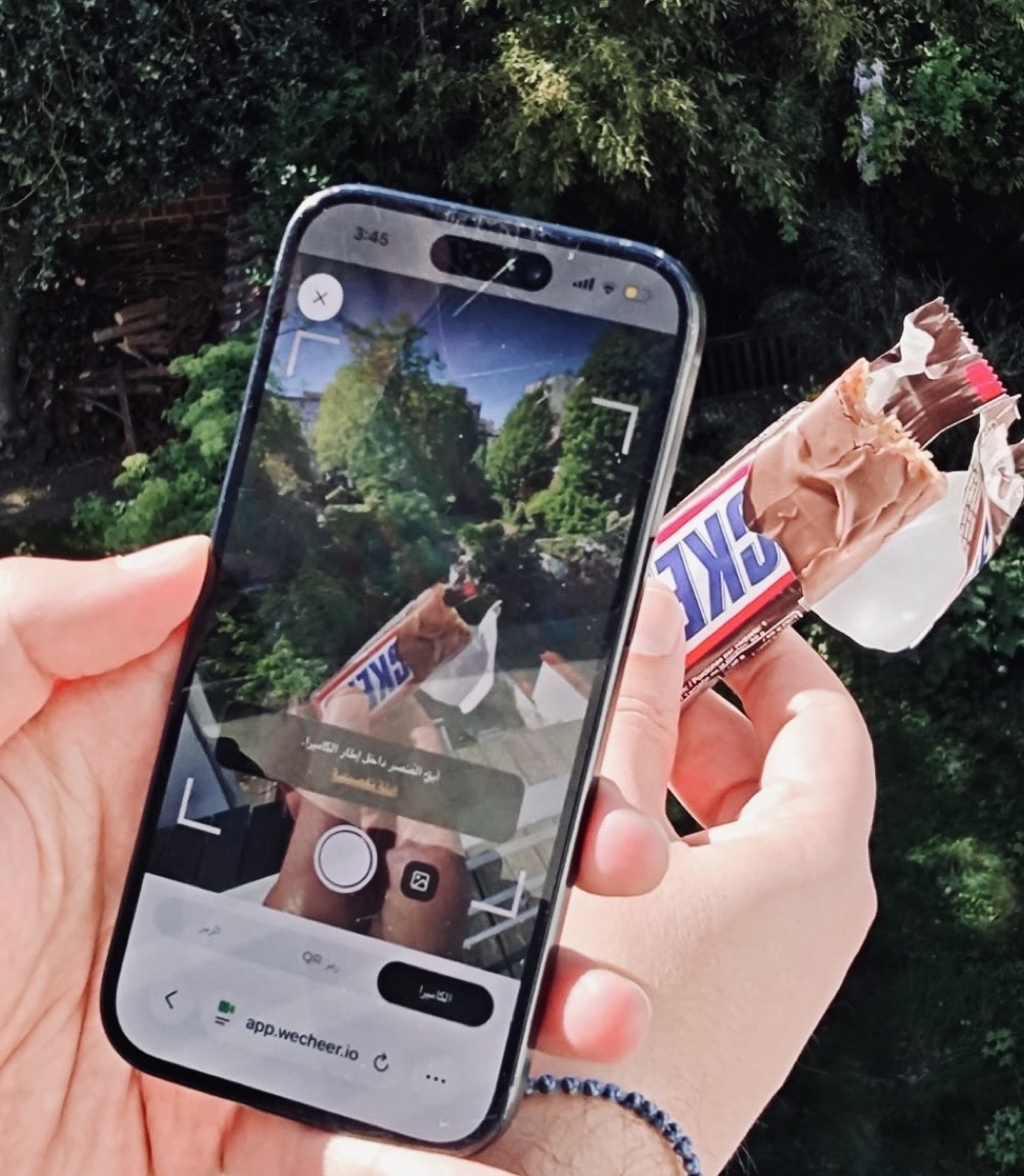 A consumer scanning a Snickers bar with Wecheer Snap & Earn to validate real consumption